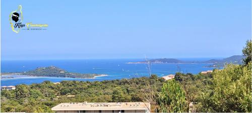 - une vue sur l'océan depuis une colline avec un bâtiment dans l'établissement Paradiso T3 vue Mer Piscine Partagée, à Porto-Vecchio