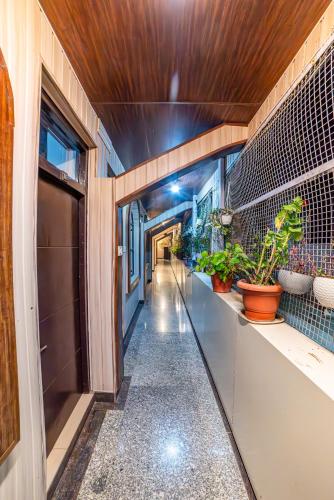 a hallway with potted plants on the wall at The Bunkk Inn Hotel & Restaurant - Mussoorie International in Mussoorie