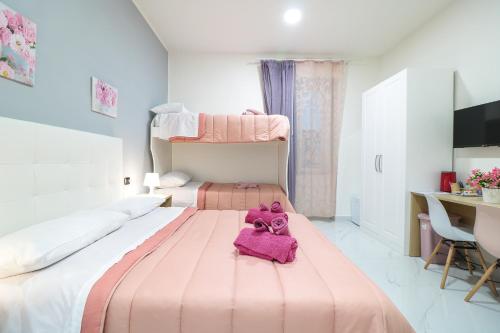 a pink teddy bear sitting on top of a bed at B&B Italia in Ercolano