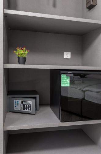 a microwave sitting on a shelf next to a bed at Boutique Suites Joyce in Pula