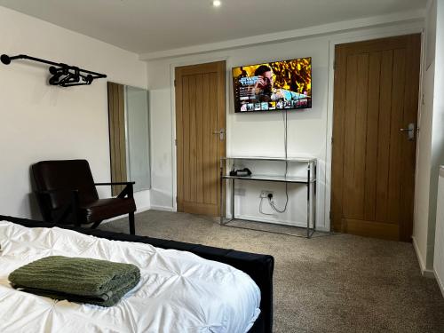 a bedroom with a bed and a tv on the wall at Entire Apartment super king bed close to Town Centre in Colchester