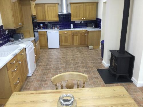 a kitchen with a stove and a chair in it at Applewood in South Wheatley
