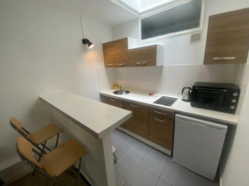 une petite cuisine avec un évier et un micro-ondes dans l'établissement Jolie 2 pieces metro voltaire - Paris 11 - 2P, à Paris