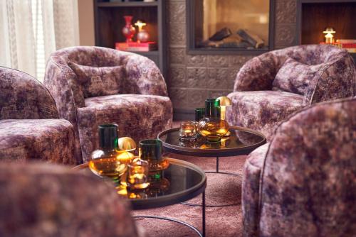 a living room with two chairs and two tables at The Yard hotel Noordkade in Veghel
