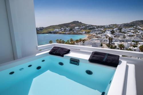 a bath tub with a view of the ocean at Deliades Hotel in Ornos