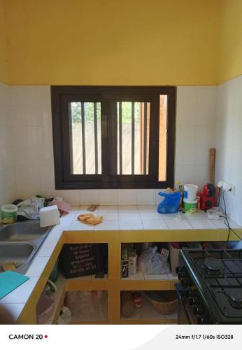a kitchen with a counter top and a window at chambre indépendante in Cap Skirring