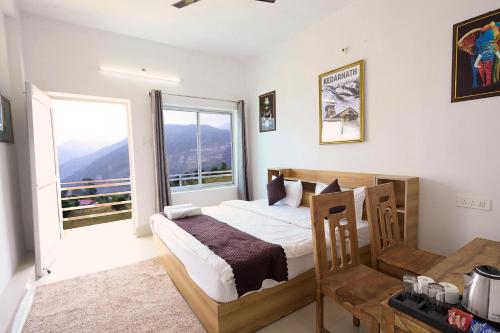 a bedroom with a bed and a large window at LA Riqueza Sushanti Retreat - Mountain View Rooms with Balcony # Pure Veg Restaurant # Jain Food Available # Parking # Customer's choice Hotel in Gupta Kāshi