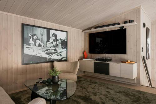 a living room with a tv and a glass table at Modern Top Floor Apartment By Kvitfjell Ski Resort in Favang