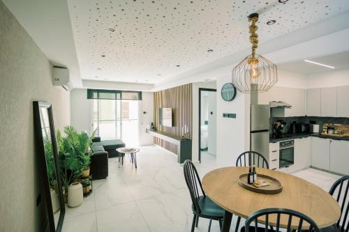 a kitchen and living room with a table and chairs at 2BR Amalfi Blue Apt in Larnaca - Pool & 10Min Walk to Mackenzie Beach! in Larnaca