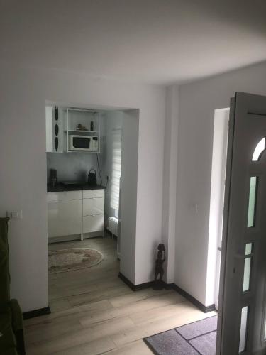 a white room with a kitchen with a microwave at Studio Faleză Nord-Banu Mihalcea in Constanţa