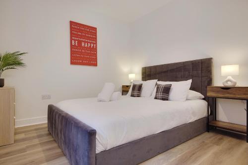 a bedroom with a large bed with white sheets and pillows at Wimborne Road Apartment 4 in Bournemouth