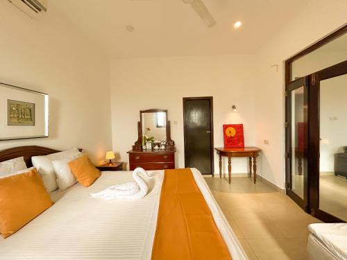 a bedroom with a large bed with a mirror at Maria Villa by Blue Bird in Negombo