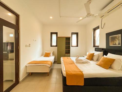 a bedroom with two beds and a swan on the bed at Maria Villa by Blue Bird in Negombo