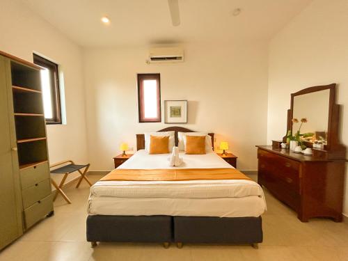 a bedroom with a large bed and a mirror at Maria Villa by Blue Bird in Negombo