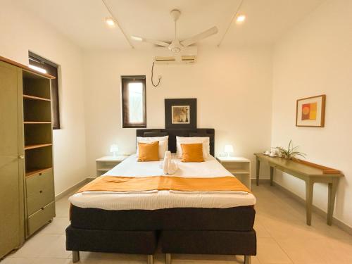 a bedroom with a large bed and a desk at Maria Villa by Blue Bird in Negombo