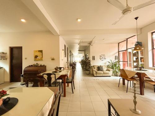 a living room with tables and chairs and a couch at Maria Villa by Blue Bird in Negombo