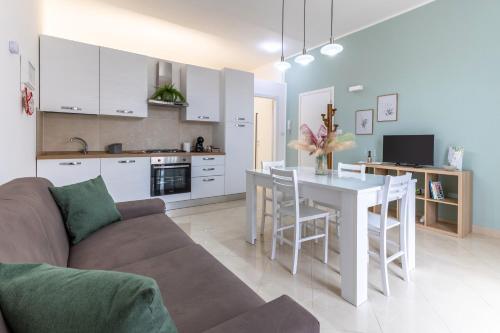 a kitchen and living room with a couch and a table at Dimora Biscari in Acate