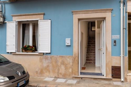 a blue building with two windows and a staircase at Dimora Biscari in Acate