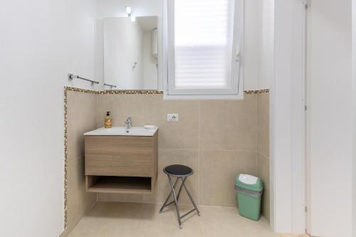 a bathroom with a sink and a stool at Dimora Biscari in Acate