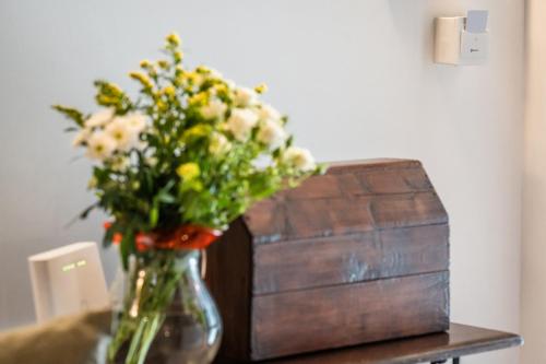 a vase of flowers on a table next to a wooden box at Antica Locanda in Monterosi