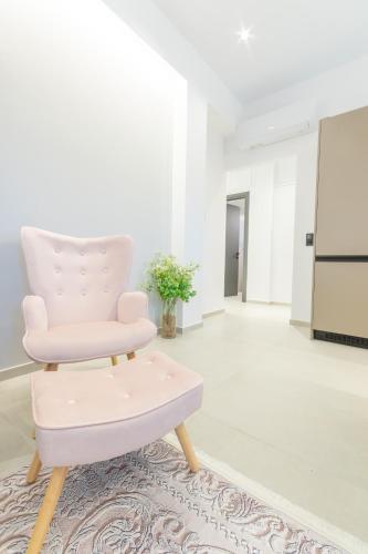 a pink chair in a white room with a rug at Serein Houses -No1- in Gargaliánoi