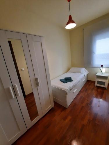 a small bedroom with a bed and a wardrobe at Turística Cervantes in Priego de Córdoba