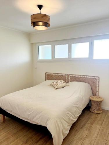 - une chambre avec un lit blanc et une lumière dans l'établissement 3 pièces au centre de Juan les Pins, à Juan-les-Pins