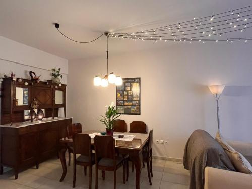 a living room with a dining room table and a kitchen at C' est la vie in Nafplio