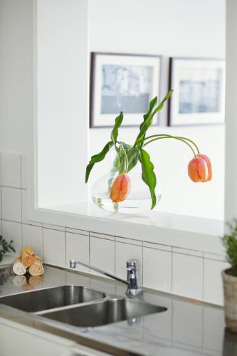 a kitchen sink with a vase with a plant in it at Villa Marstrand in Marstrand
