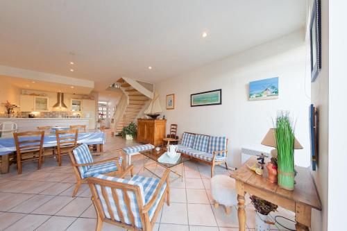 Il comprend un salon avec des chaises et des tables ainsi qu'une cuisine. dans l'établissement 022 Le petit clos, au Bois-Plage-en-Ré