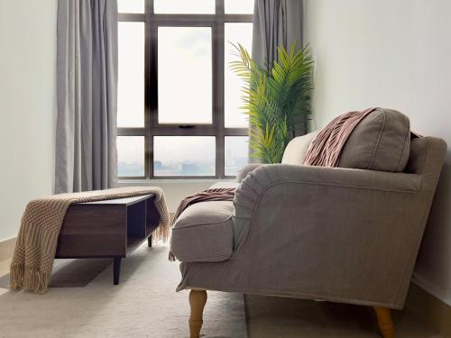 a living room with a chair and a large window at Shaftsbury Cyberjaya in Cyberjaya