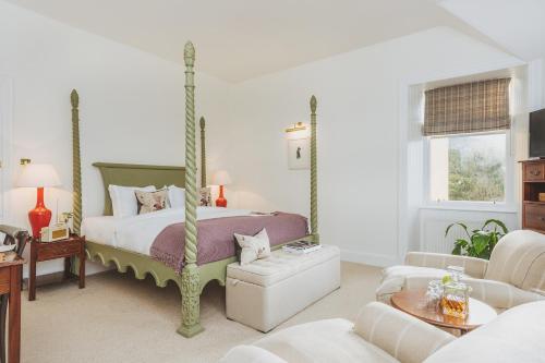 a bedroom with a canopy bed and a living room at Craigellachie Hotel of Speyside in Craigellachie