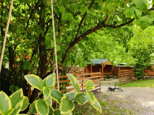a tree with a wooden fence and a cabin at Villa Maxi Likani in Borjomi