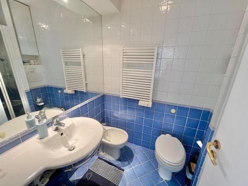 La salle de bains est pourvue de carrelage bleu, d'un lavabo et de toilettes. dans l'établissement 3P Bright in Palm Beach, à Cannes