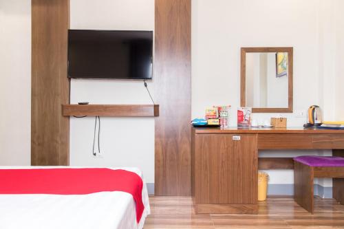 a room with a bed and a desk with a television at Mai Hotel My Dinh 미딩 in Hanoi