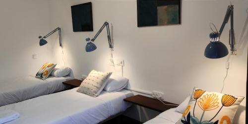 two beds in a room with blue lights on the wall at El Tercer Piso in Puente la Reina