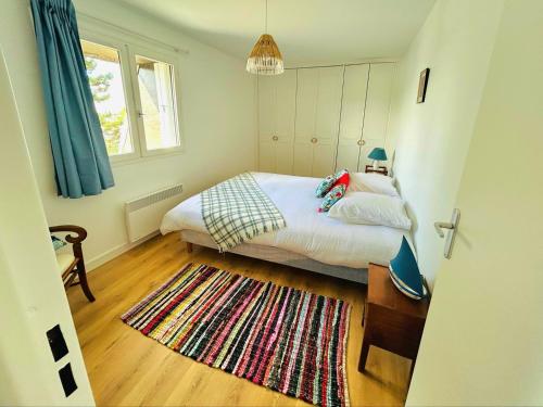 - une petite chambre avec un lit et un tapis dans l'établissement L'albatros - F2 à Cabourg, à Cabourg