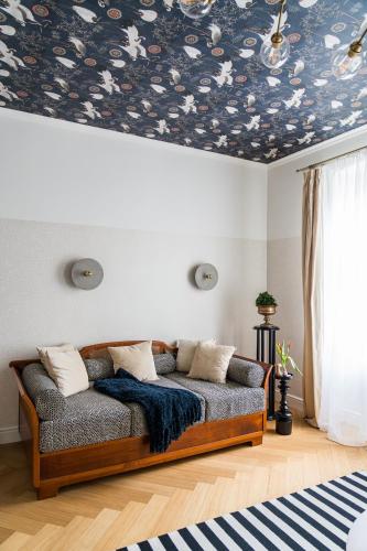 a couch in a living room with a floral ceiling at Villa Porcelaine in Keszthely