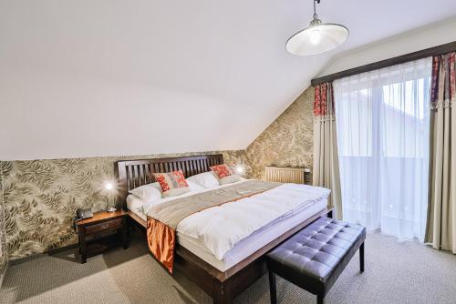 a bedroom with a large bed and a window at Penzion Drak in Liptovský Mikuláš