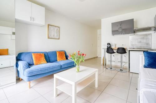 un salon avec un canapé bleu et une table dans l'établissement À deux pas de Paris - Le Confidentiel - 8MB, à Issy-les-Moulineaux