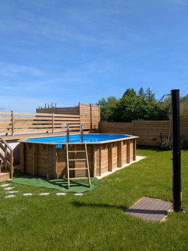 a swimming pool with a ladder in a yard at Les Jolis Nids - Studio Rouge Gorge in La Roche-Posay