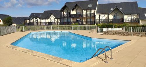 une grande piscine devant une maison dans l'établissement Brennick, Maison 4 pers proche mer et plage, à Clohars-Carnoët