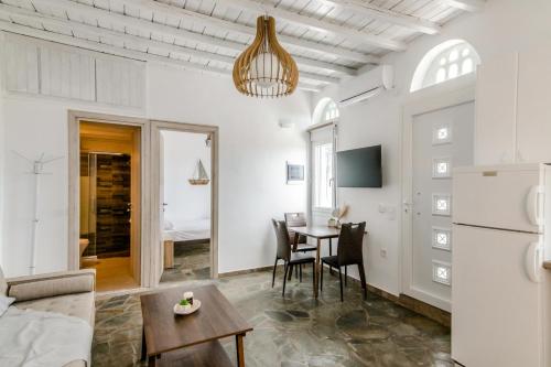 a white living room with a table and chairs at Harmony Apartment 2 in Agios Sostis