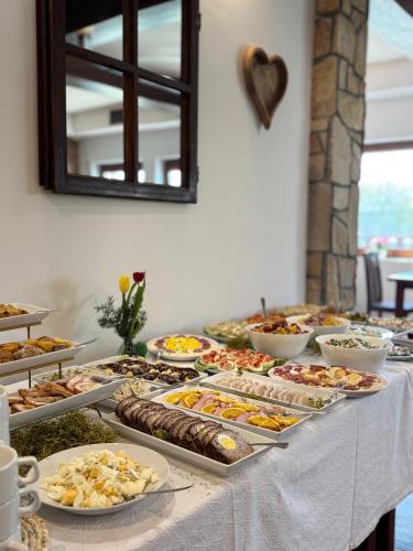 a buffet with many different types of food on a table at Bieszczadzki Dworek Polanczyk in Polańczyk
