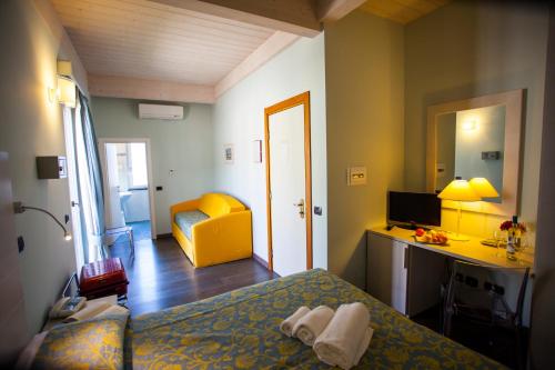a bedroom with a bed and a desk with a computer at Hotel Delle Rose in Bonassola