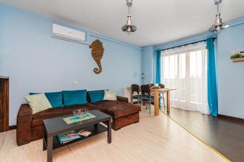 a living room with a couch and a table at Lazurowy Dwór - Przystań Latarnika Grand Apartments in Sztutowo