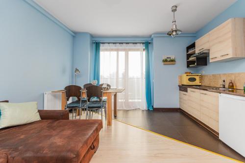 a living room with a couch and a table at Lazurowy Dwór - Przystań Latarnika Grand Apartments in Sztutowo