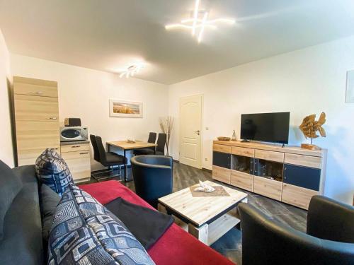 un salon avec un canapé et une télévision dans l'établissement Landhaus Kreitlow, à Ribnitz-Damgarten