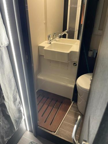 une petite salle de bain avec un lavabo et des toilettes dans l'établissement CAMPING-CAR TOURISTIQUE du JURA, à Dole