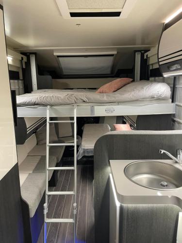 Cette chambre comprend 2 lits superposés et un lavabo. dans l'établissement CAMPING-CAR TOURISTIQUE du JURA, à Dole